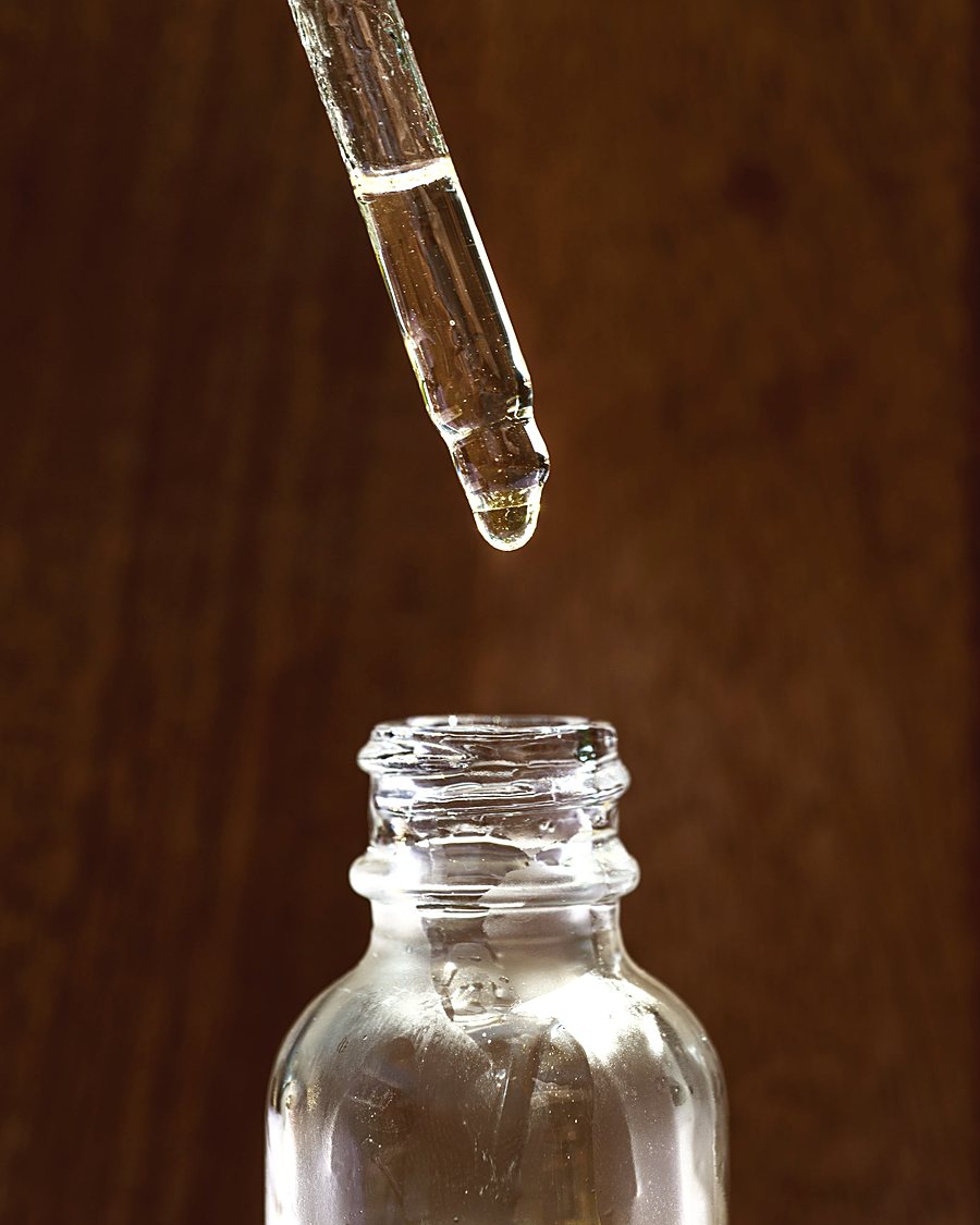 A dropper held above an open bottle